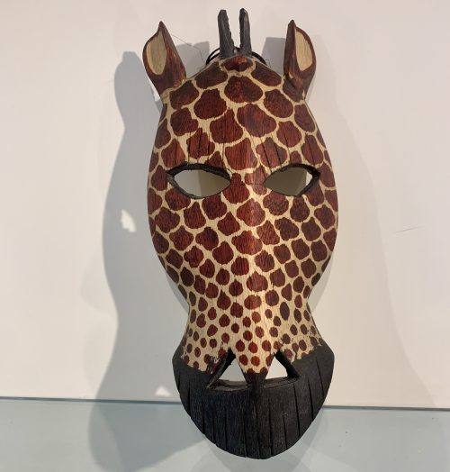 Masker Giraffe gemaakt van mahonie en afkomstig uit Kenia. 24 cm. hoog en 12 cm. breed.