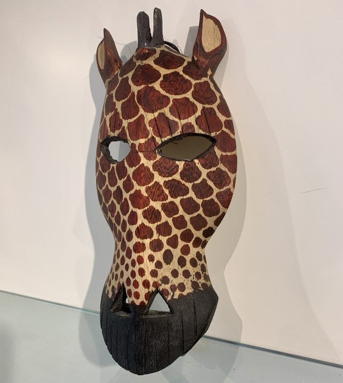 Masker Giraffe gemaakt van mahonie en afkomstig uit Kenia. 24 cm. hoog en 12 cm. breed.